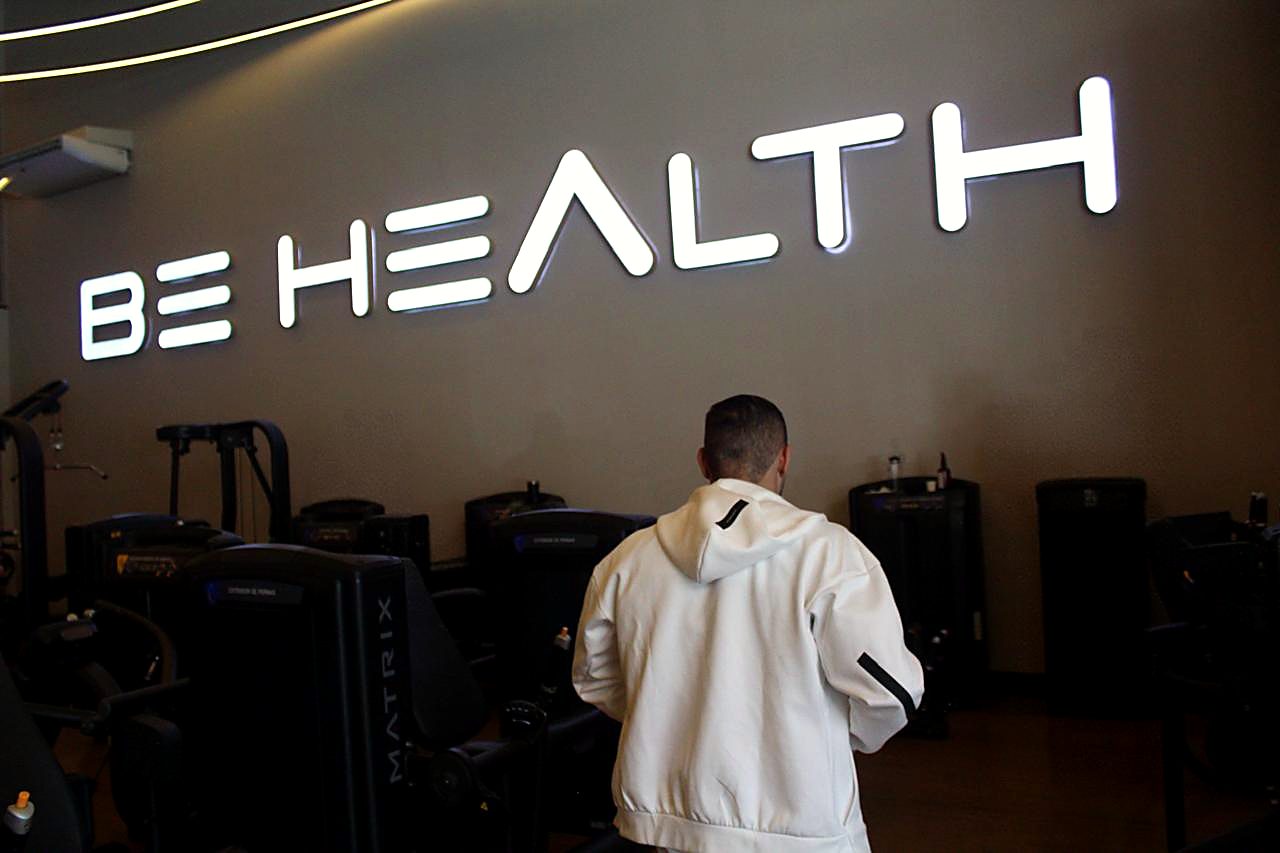 Pedro Aldana de costas, diante do letreiro da Be Health Sport